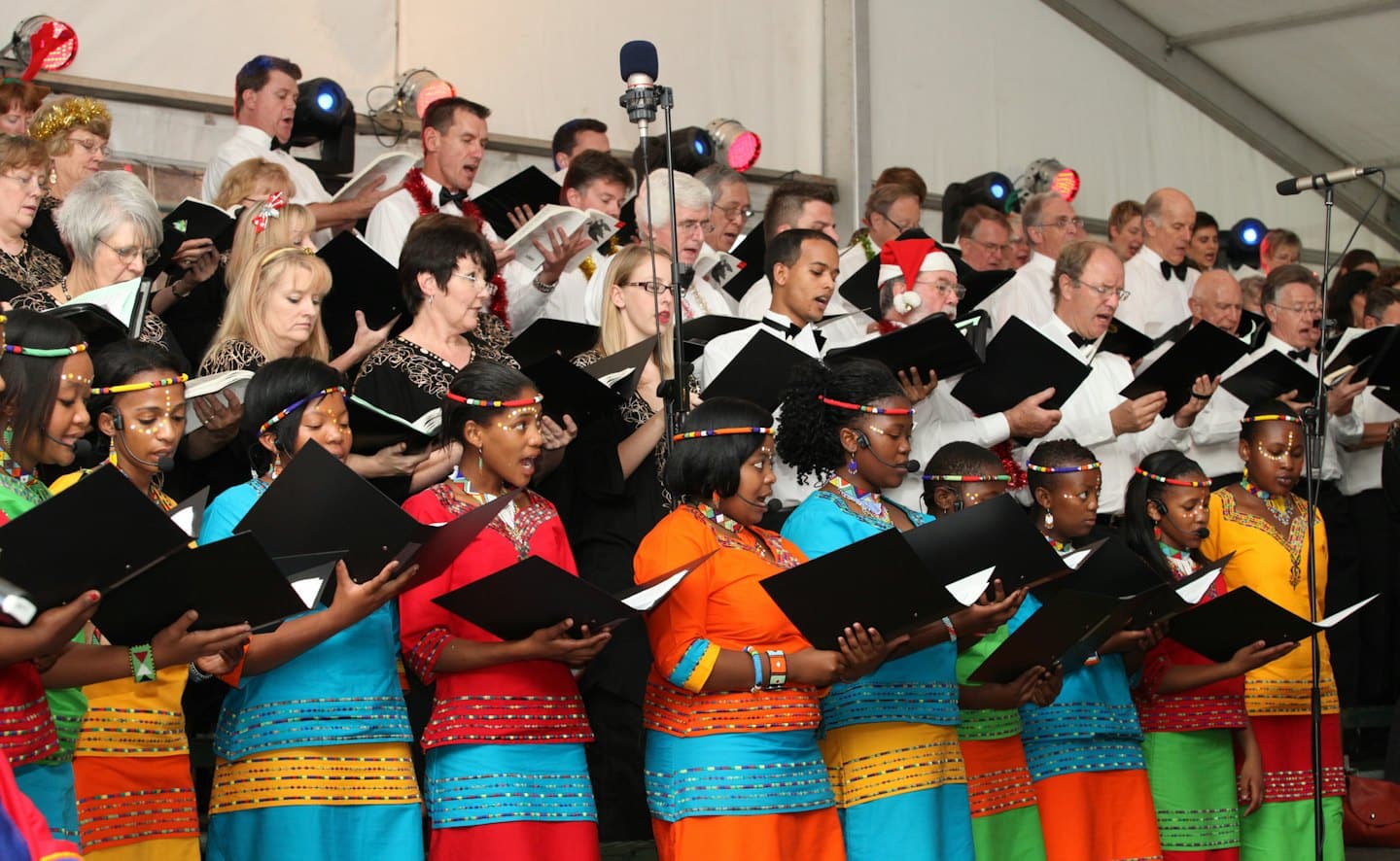 Ein vielfältiger Chor singt gemeinsam bei einem festlichen Weihnachtskonzert.